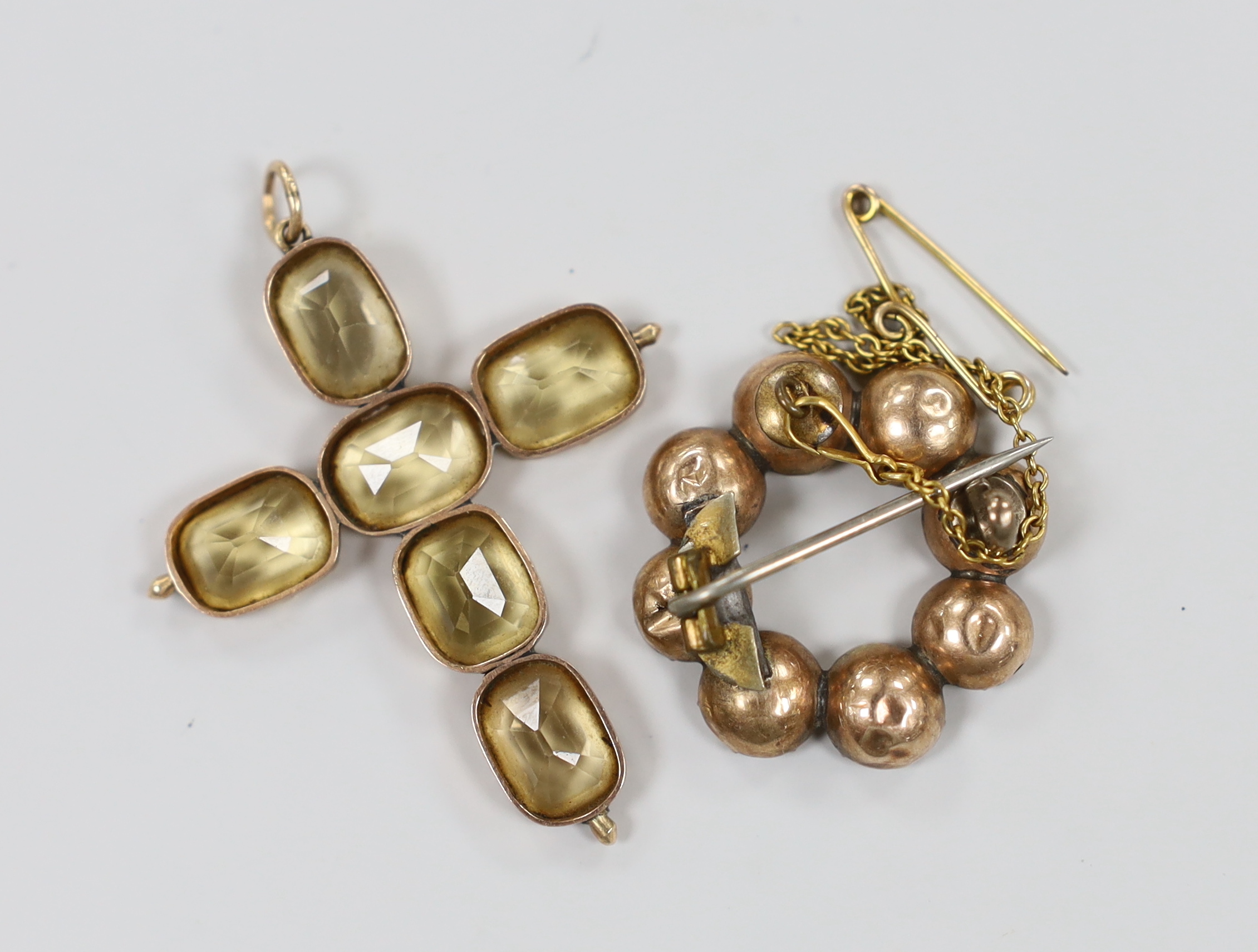 A yellow metal and six stone oval cut yellow topaz set cross pendant, 45mm and a similar eight stone set brooch, gross weight 9.4 grams.